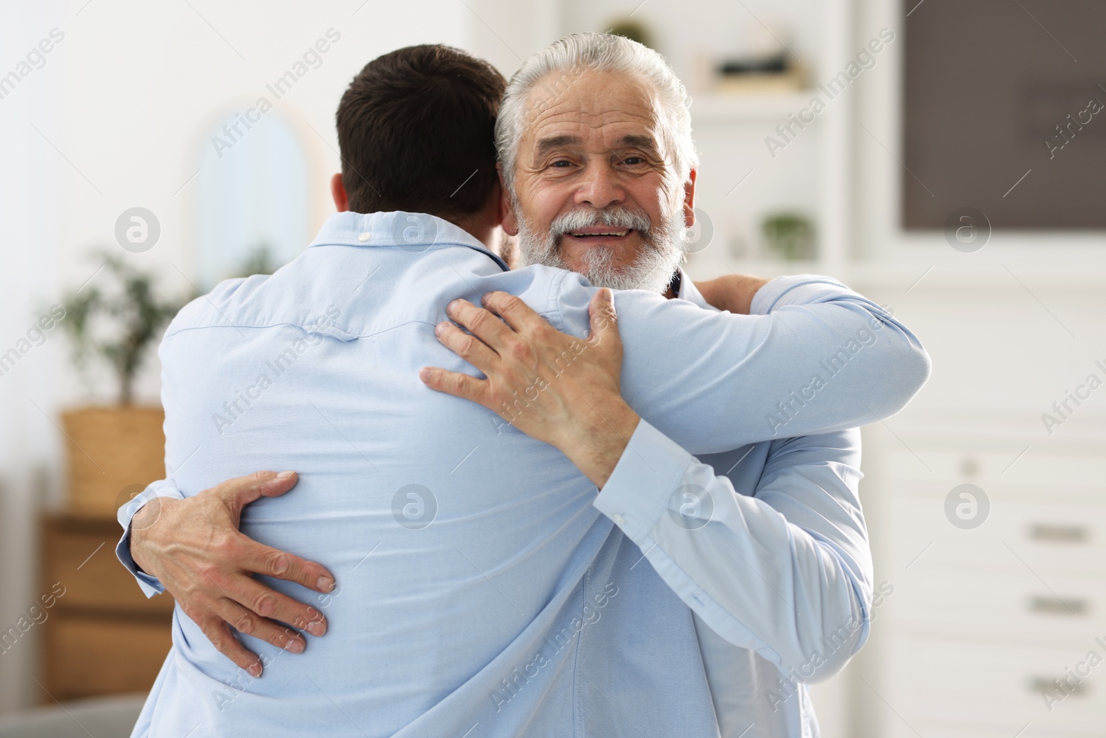 Photo of Happy dad and his son hugging at home