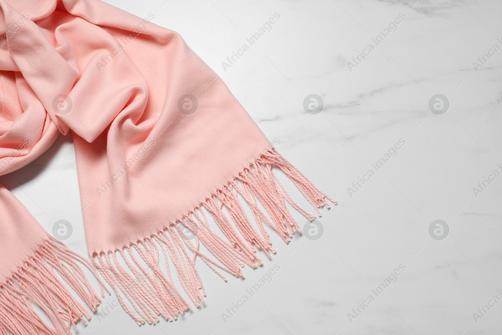 Photo of Soft cashmere scarf on white marble table, top view. Space for text