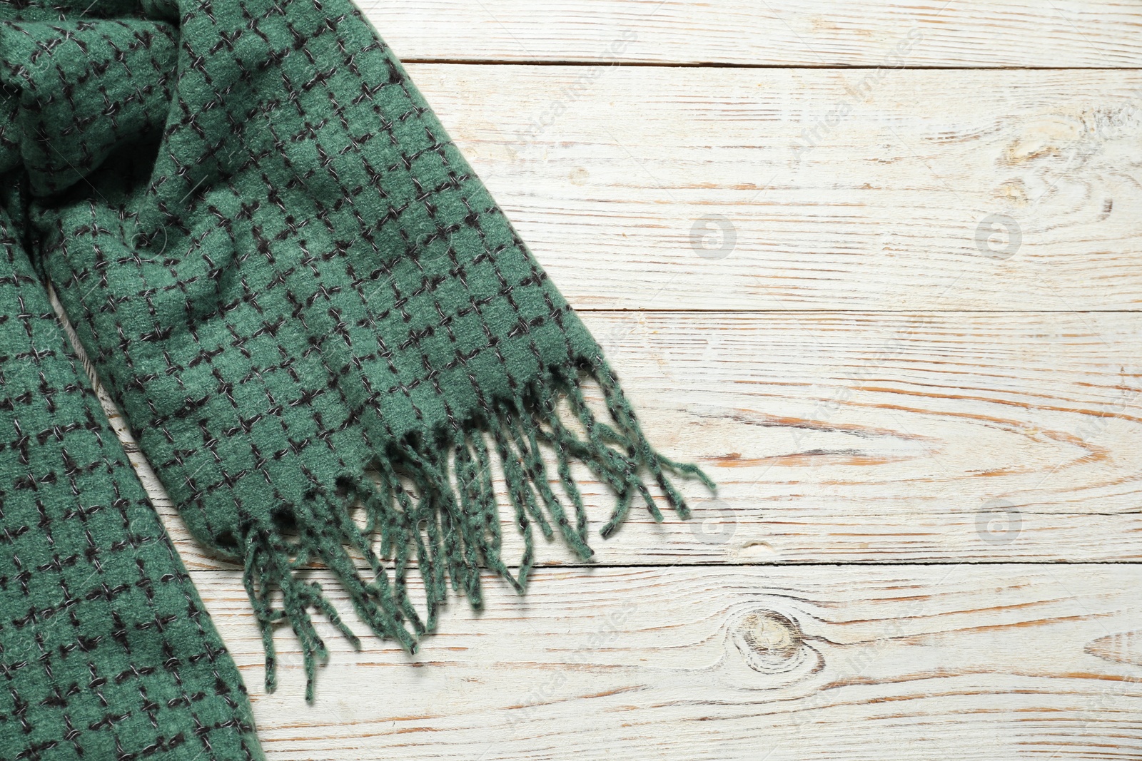 Photo of Soft green scarf on white wooden table, top view. Space for text