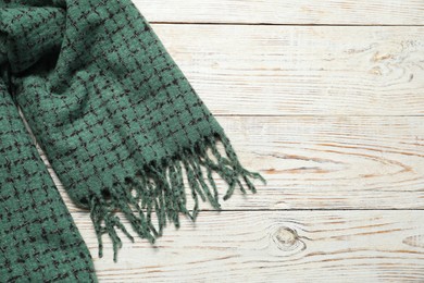 Soft green scarf on white wooden table, top view. Space for text