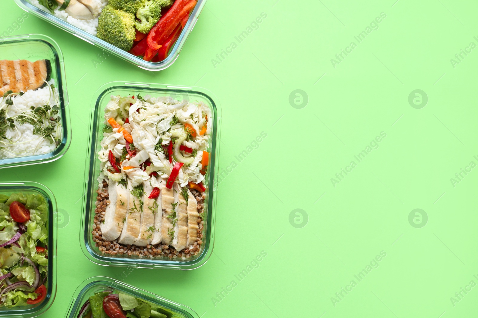 Photo of Healthy food. Different meals in glass containers on green background, flat lay. Space for text