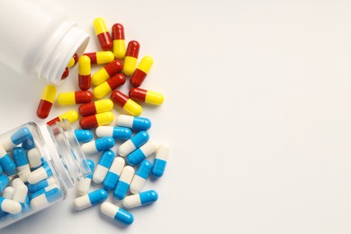 Photo of Antibiotic pills and bottles on white background, flat lay. Space for text