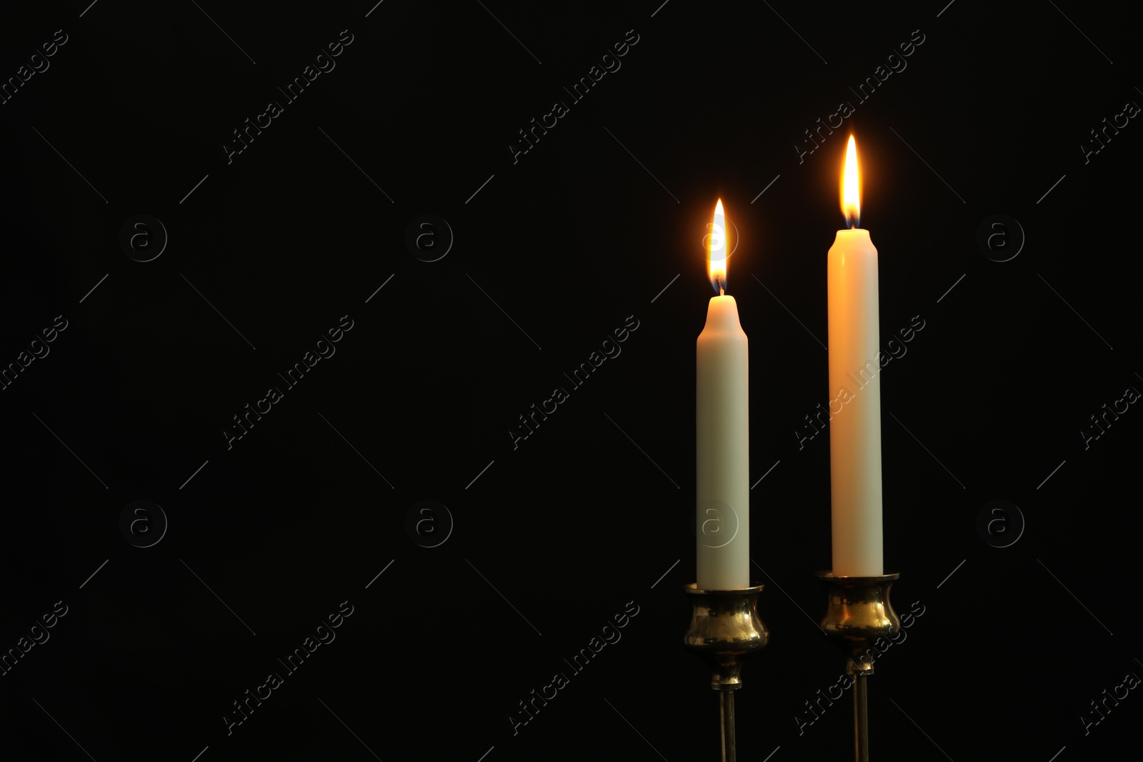 Photo of Burning candles on black background. Space for text