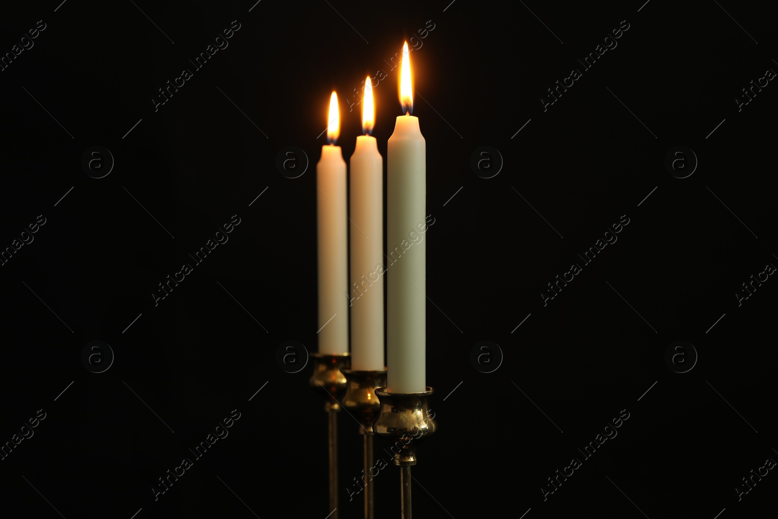 Photo of Burning candles on black background. Space for text