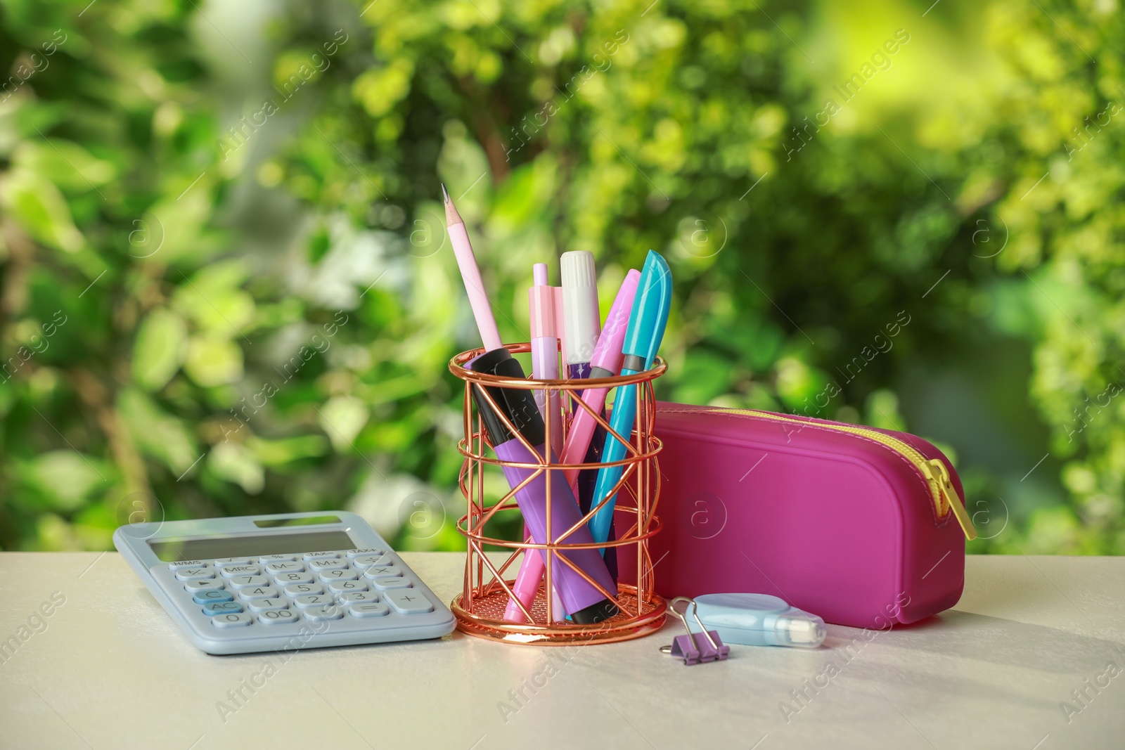 Photo of Holder, pencil case, calculator and other different stationery on white table