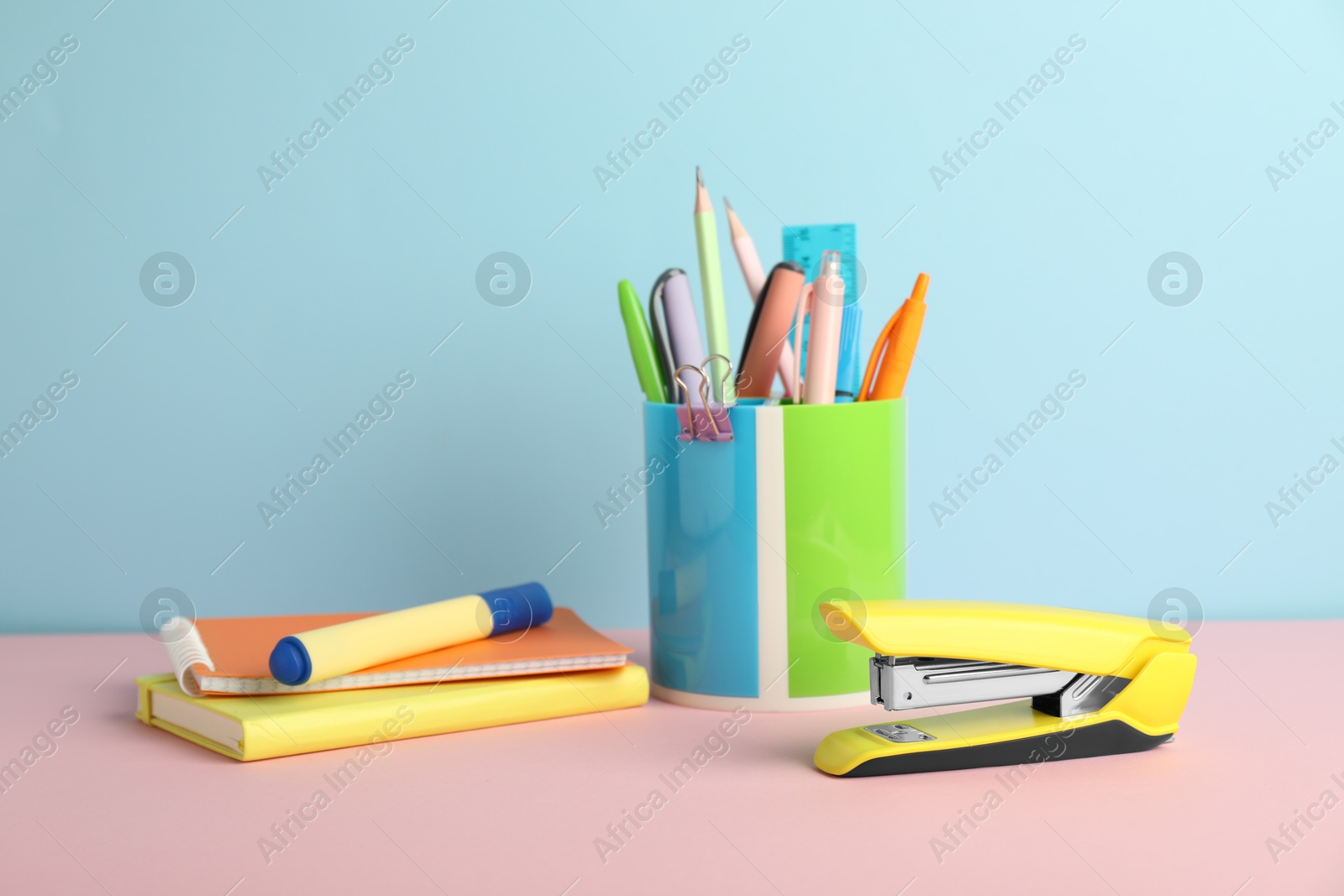 Photo of Yellow stapler and other stationery on color background