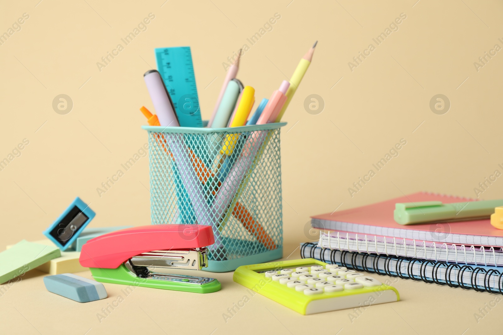 Photo of Bright stapler and other stationery on beige background