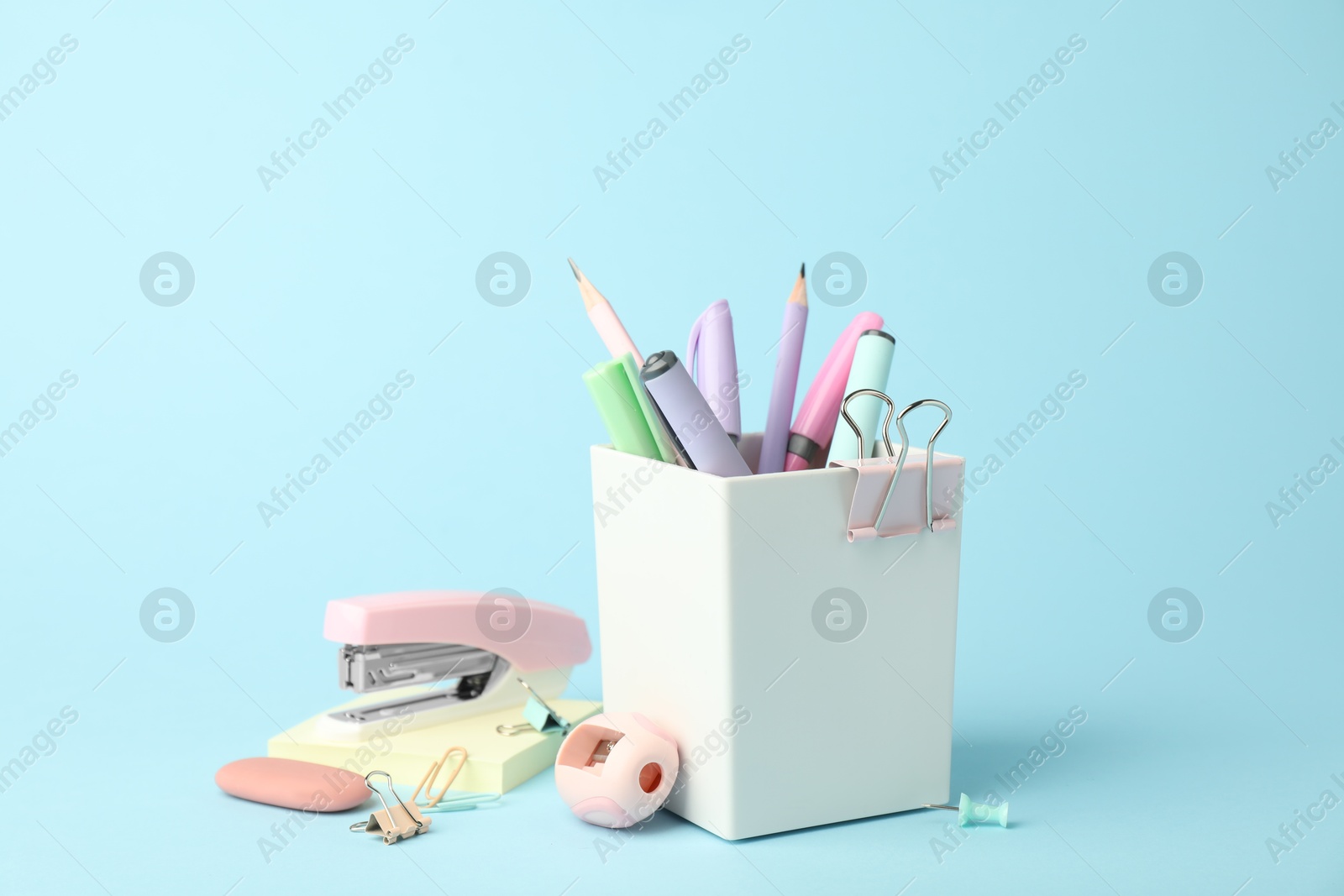 Photo of Stapler and other stationery on light blue background