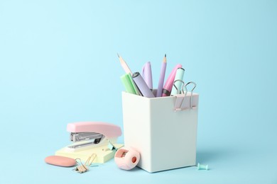 Photo of Stapler and other stationery on light blue background