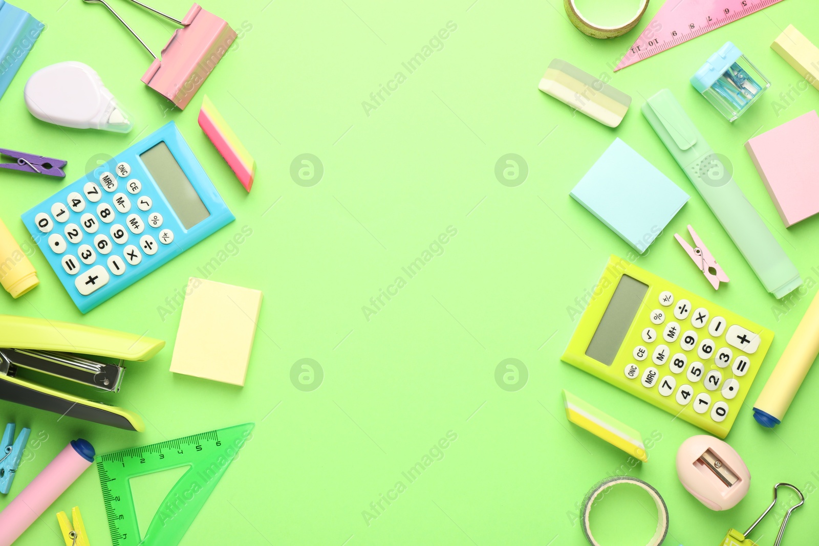 Photo of Bright stapler and other stationery on green background, flat lay. Space for text