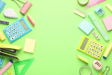 Bright stapler and other stationery on green background, flat lay. Space for text