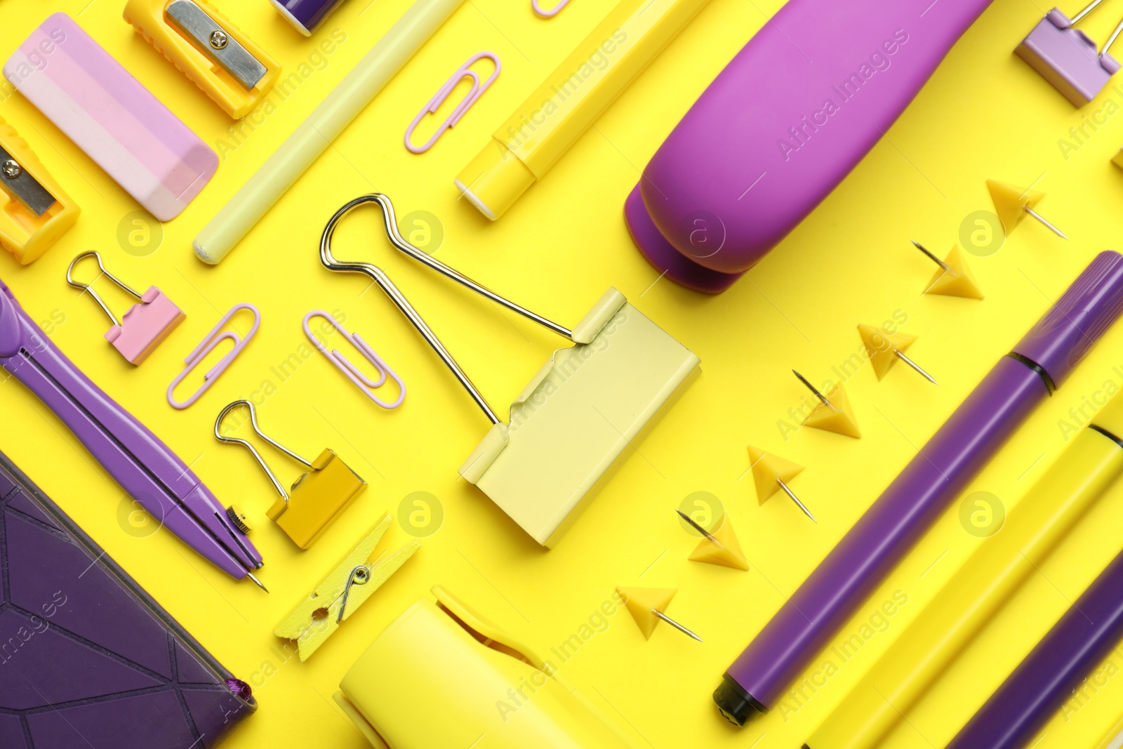 Photo of Flat lay composition with notebook, stapler and different stationery on yellow background