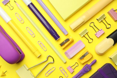 Flat lay composition with notebooks, stapler and different stationery on yellow background