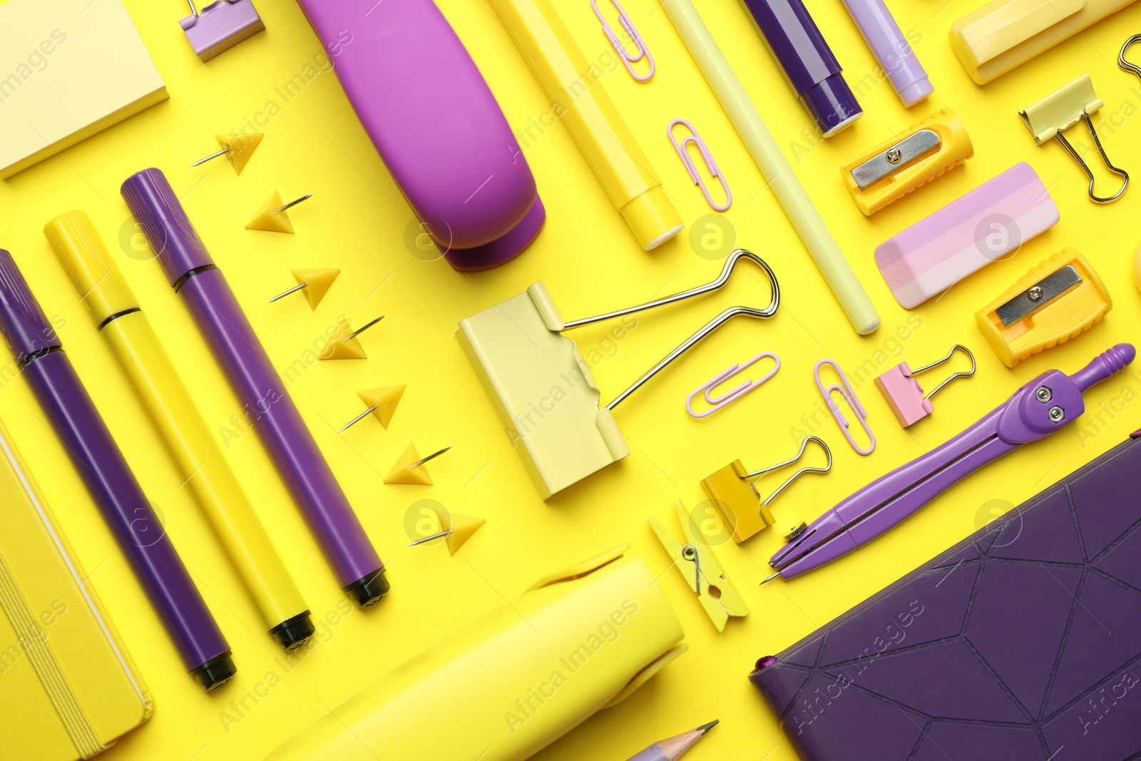 Photo of Flat lay composition with notebook, stapler and different stationery on yellow background