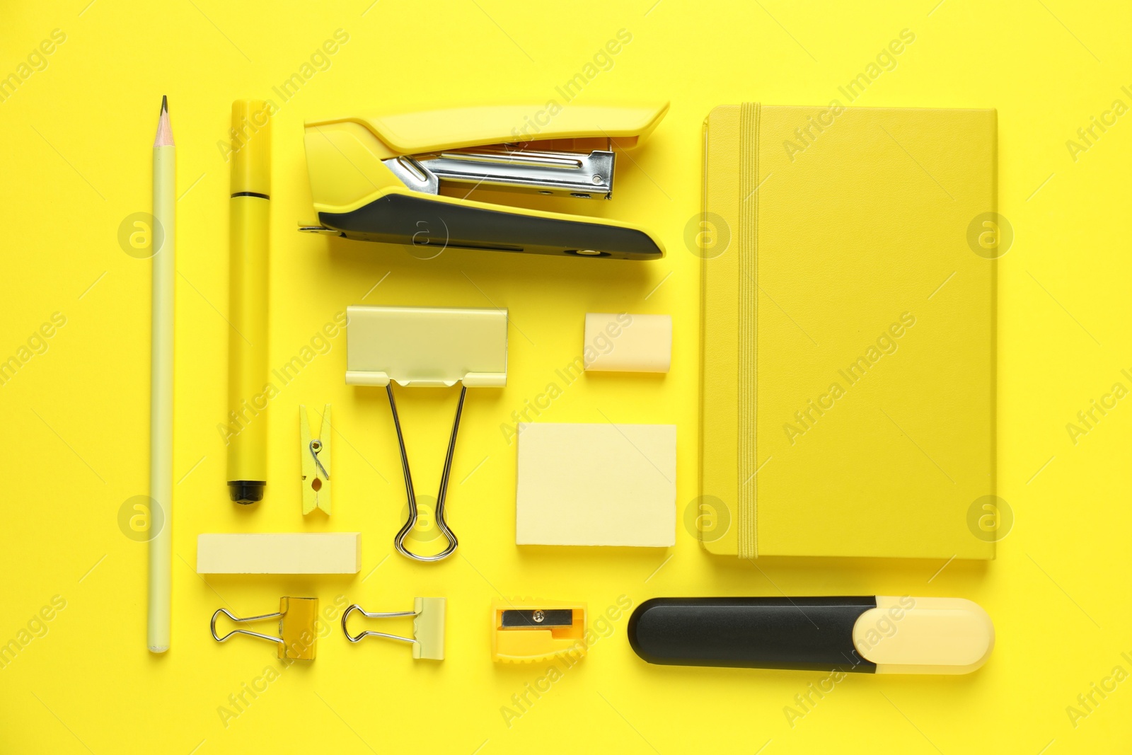 Photo of Flat lay composition with notebook, stapler and different stationery on yellow background