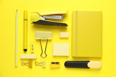 Flat lay composition with notebook, stapler and different stationery on yellow background