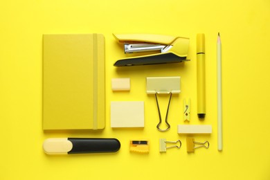 Photo of Flat lay composition with notebook, stapler and different stationery on yellow background