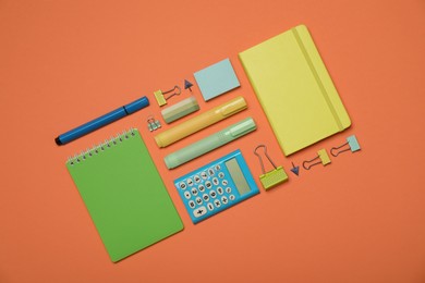 Photo of Flat lay composition with notebooks and different stationery on orange background