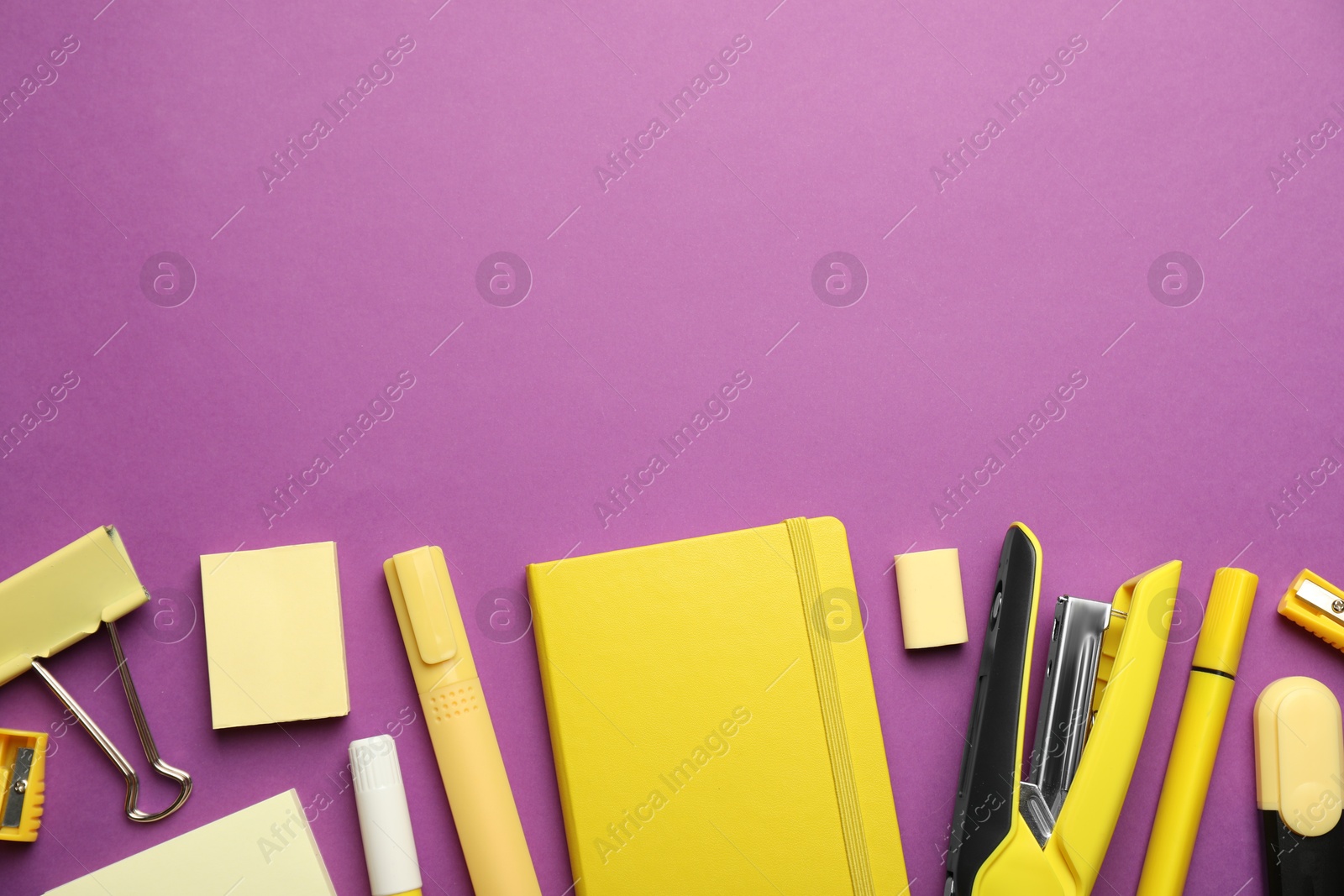 Photo of Flat lay composition with notebook, stapler and different stationery on violet background, space for text