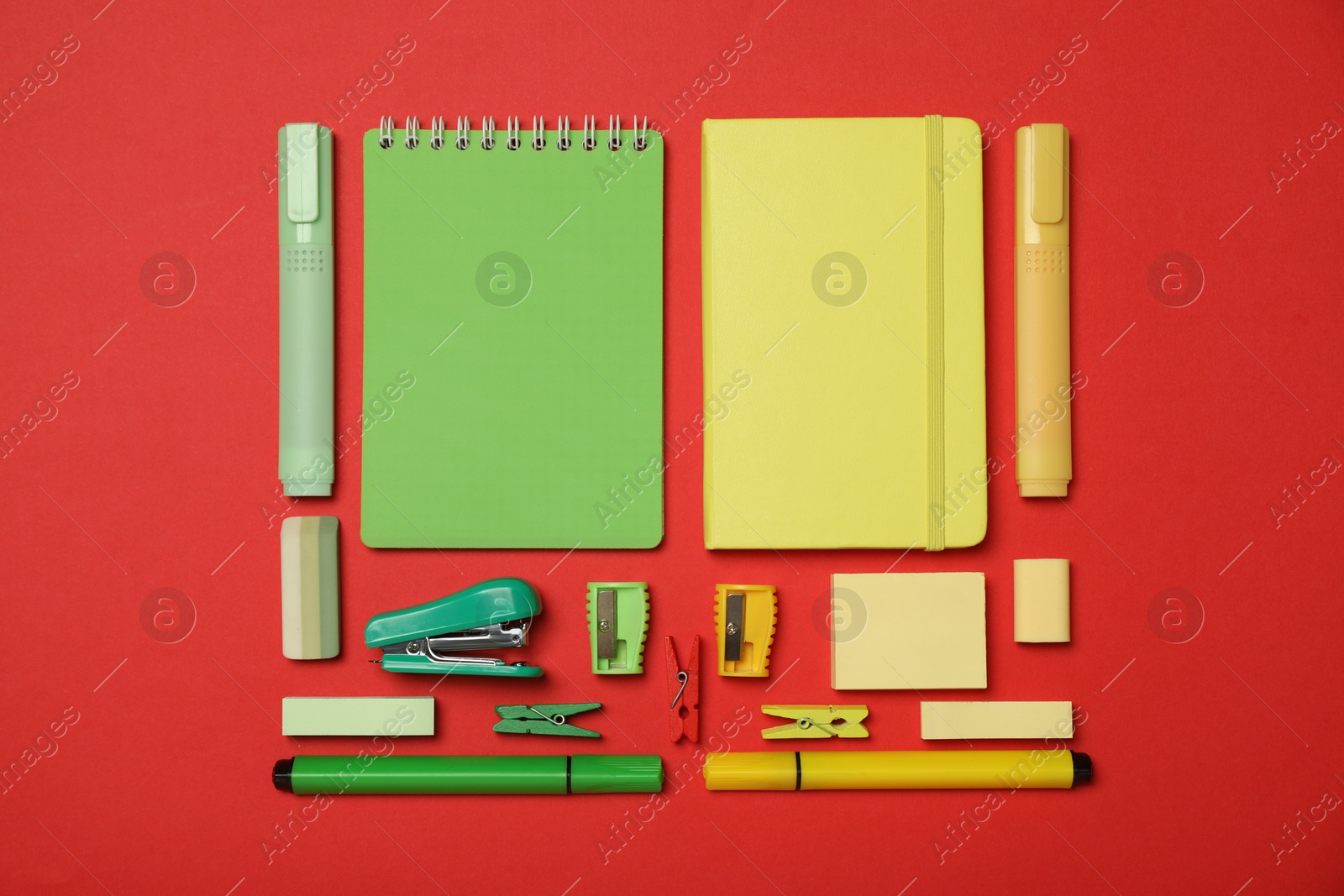 Photo of Flat lay composition with notebooks, stapler and different stationery on red background