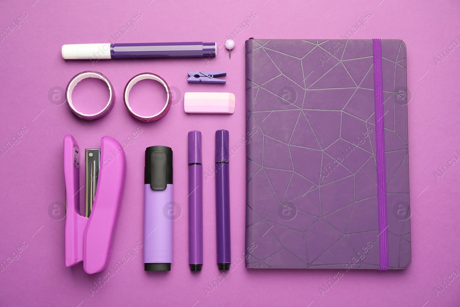 Photo of Flat lay composition with notebook, stapler and different stationery on violet background