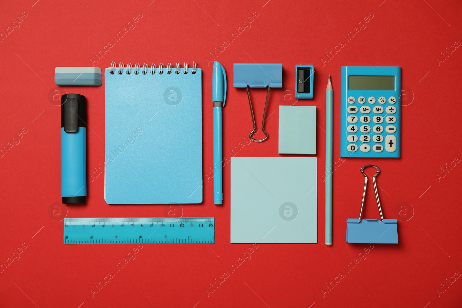 Photo of Flat lay composition with notebook and different stationery on red background