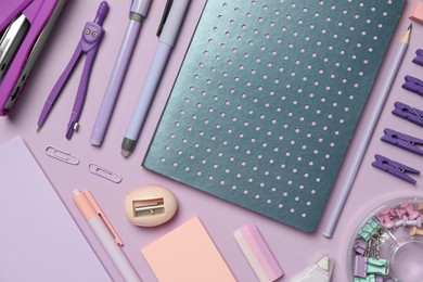 Photo of Flat lay composition with notebook, stapler and different stationery on violet background