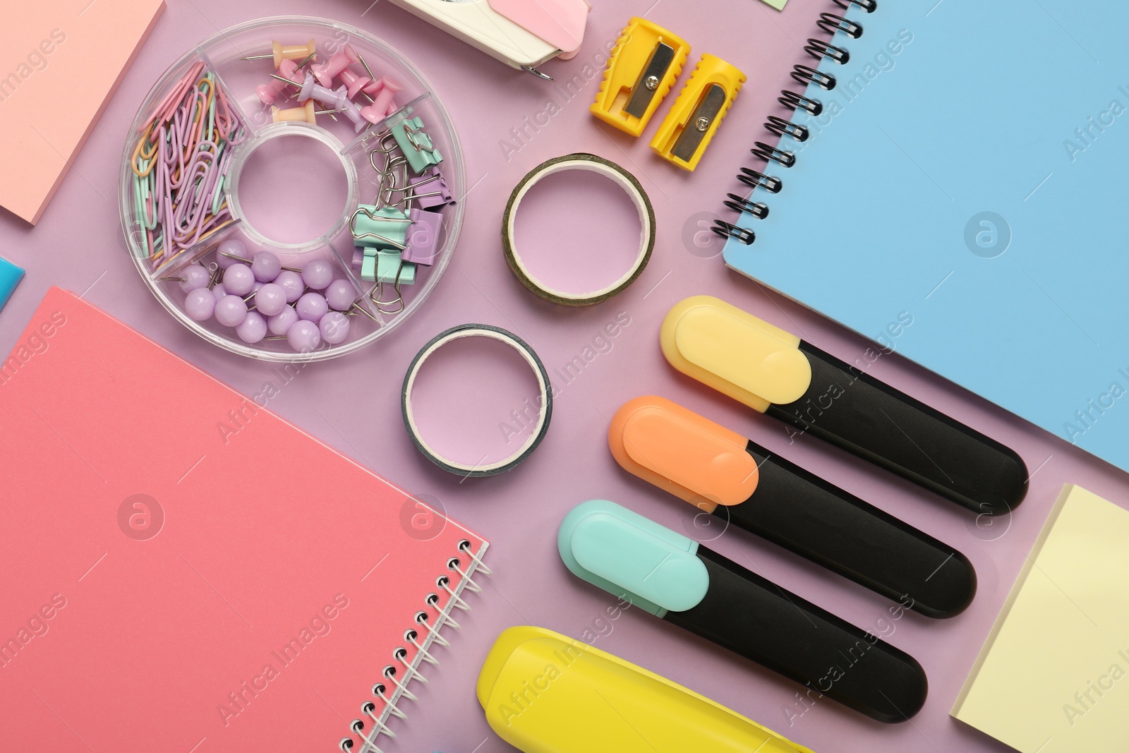 Photo of Flat lay composition with notebooks and different stationery on violet background