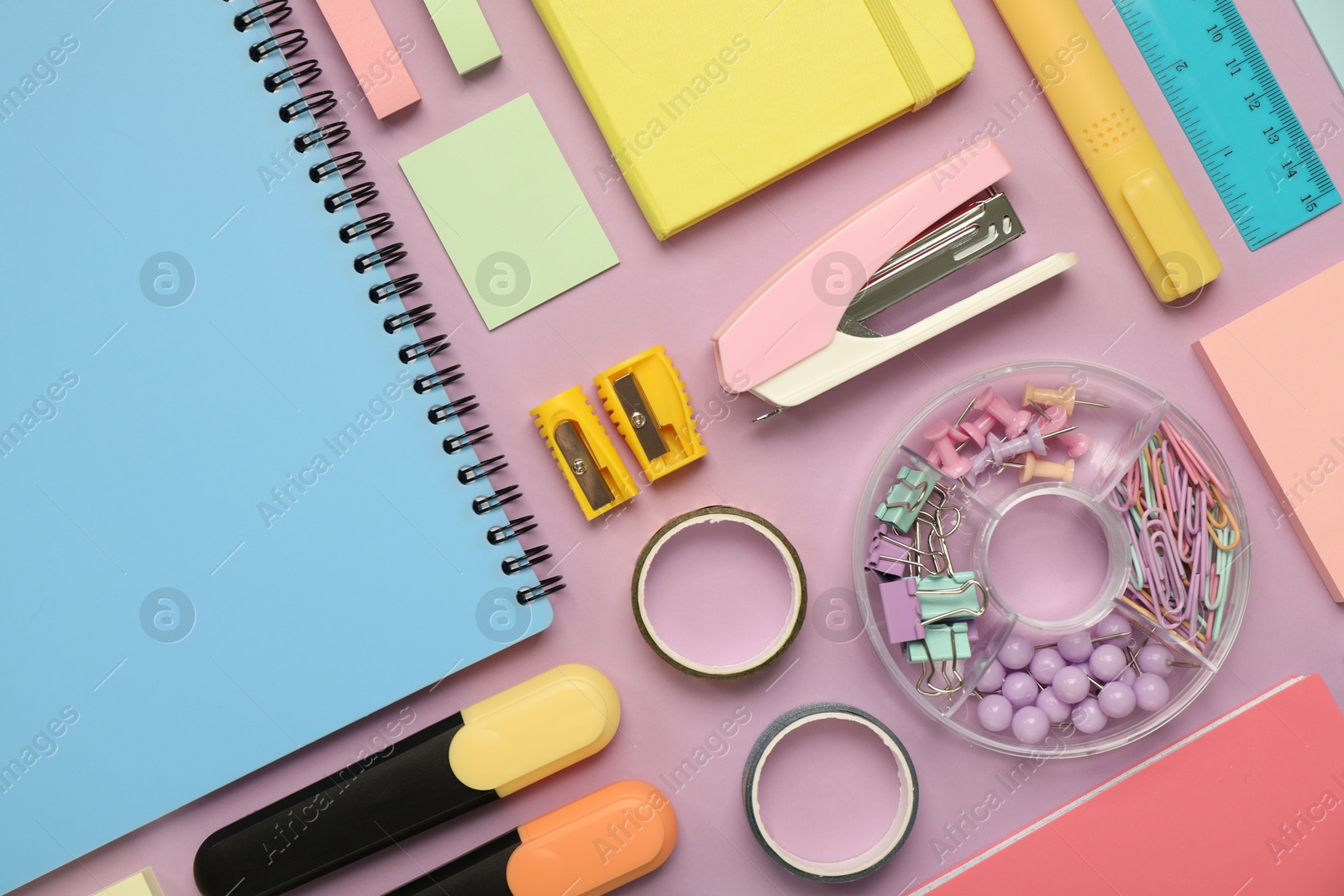 Photo of Flat lay composition with notebooks, stapler and different stationery on violet background