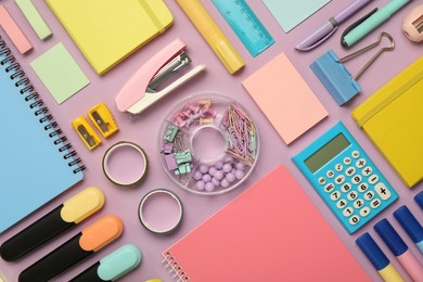 Flat lay composition with notebooks, stapler and different stationery on violet background