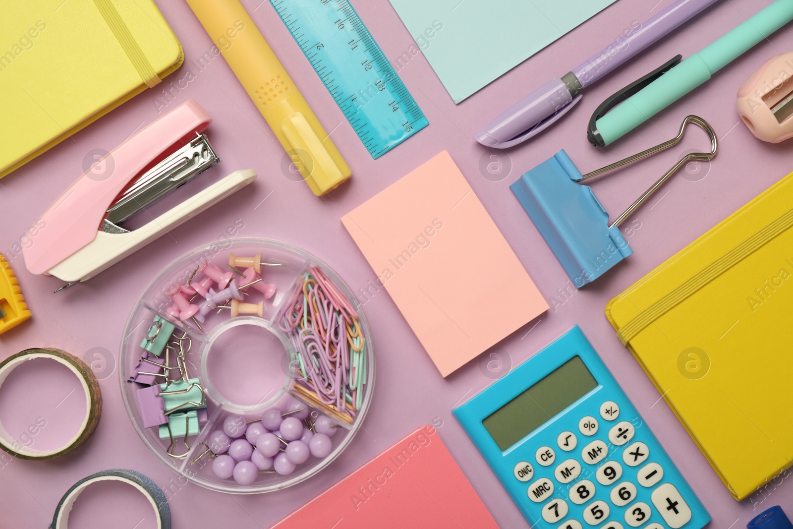 Photo of Flat lay composition with notebooks, stapler and different stationery on violet background