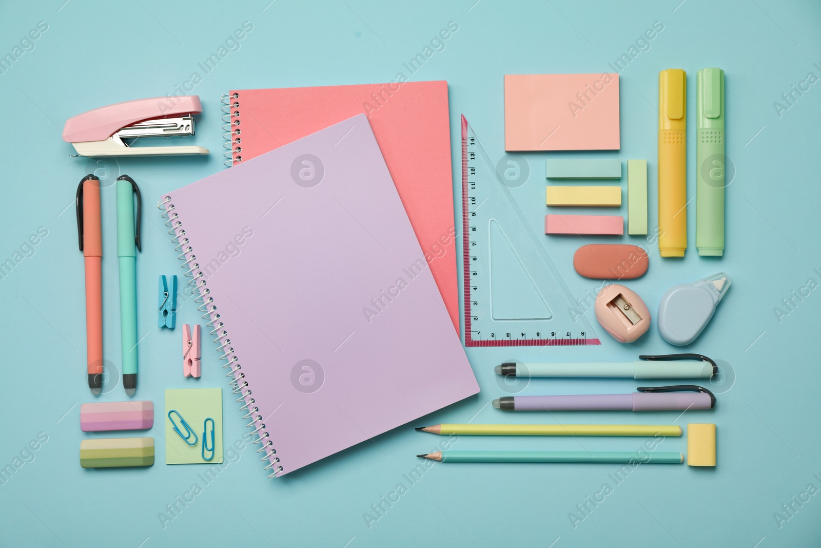 Photo of Flat lay composition with notebooks, stapler and different stationery on light blue background