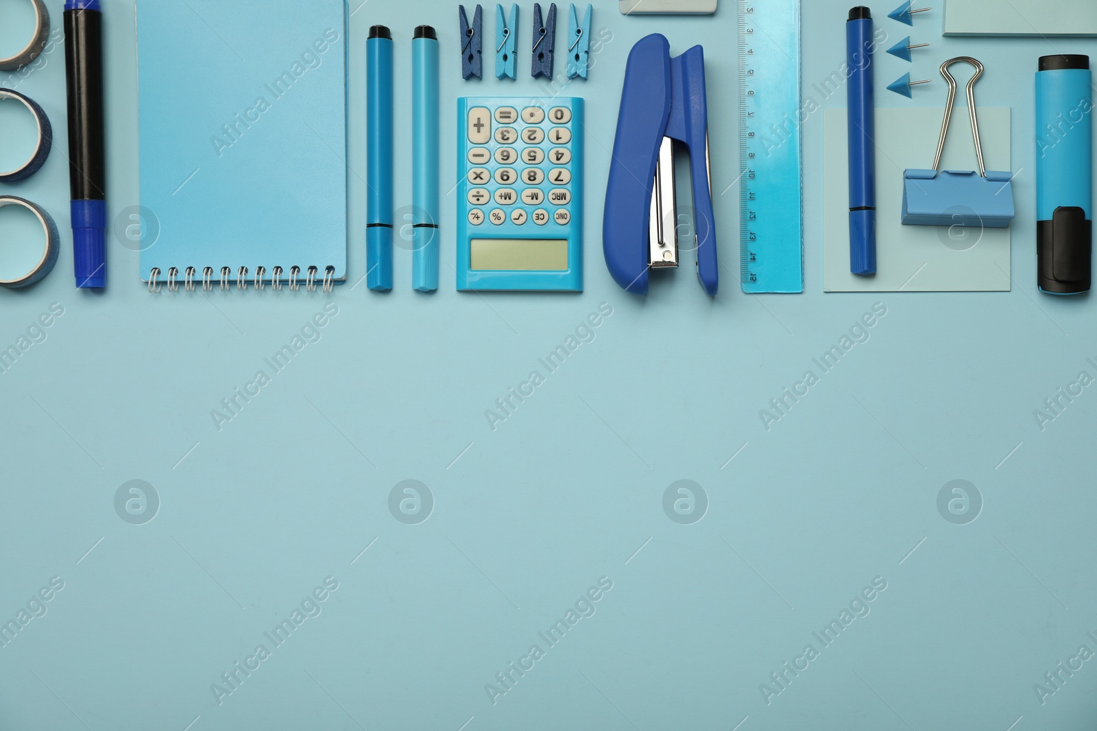 Photo of Flat lay composition with notebook, stapler and different stationery on light blue background, space for text