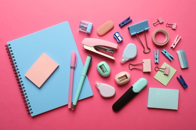 Photo of Flat lay composition with notebook, stapler and different stationery on pink background