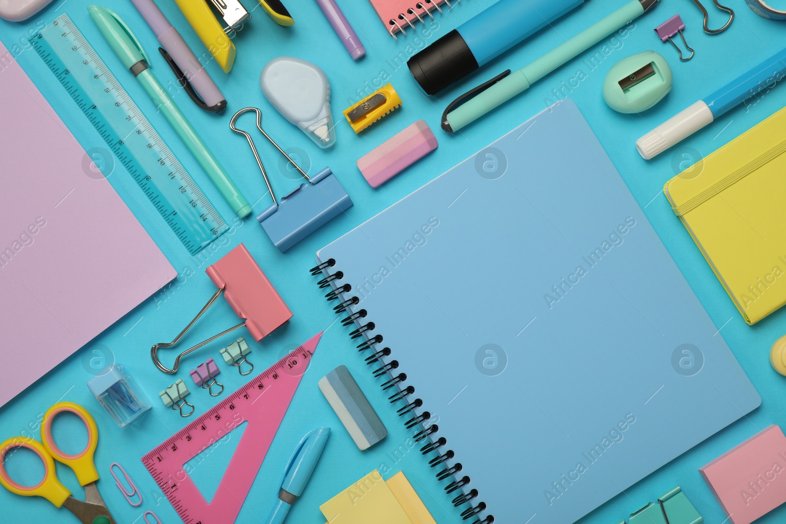 Photo of Flat lay composition with notebook and different stationery on light blue background