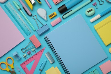 Photo of Flat lay composition with notebook and different stationery on light blue background