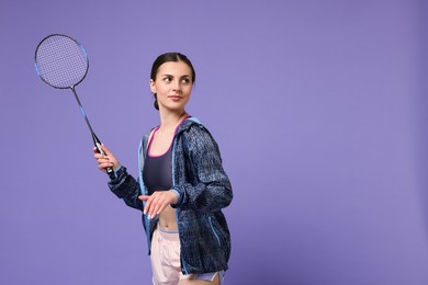 Young woman with badminton racket on purple background, space for text
