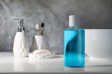 Photo of Bottle of mouthwash on light countertop in bathroom