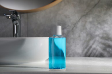 Photo of Bottle of mouthwash on light countertop in bathroom