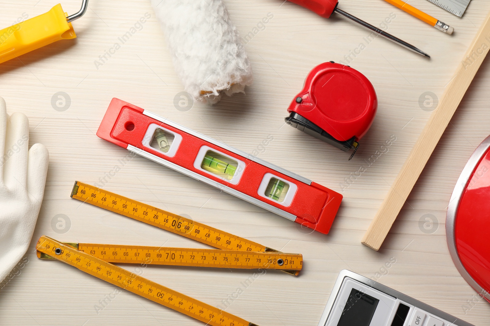 Photo of Flat lay composition with building level and other construction tools on white wooden table