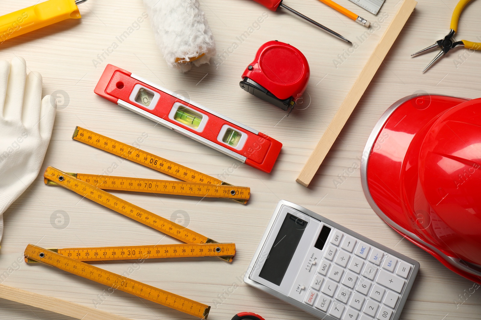 Photo of Flat lay composition with building level and other construction tools on white wooden table