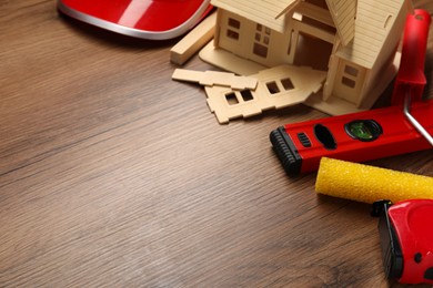 Building level and other construction tools on wooden table, closeup. Space for text