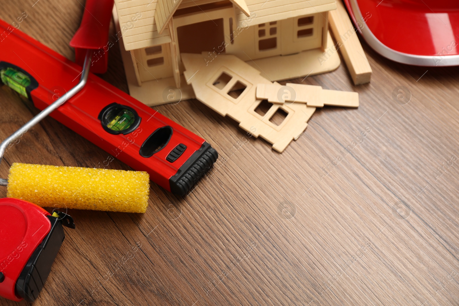 Photo of Building level and other construction tools on wooden table, closeup. Space for text
