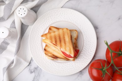 Pieces of toasted bread with melted cheese, tomatoes and spices on light marble table, flat lay