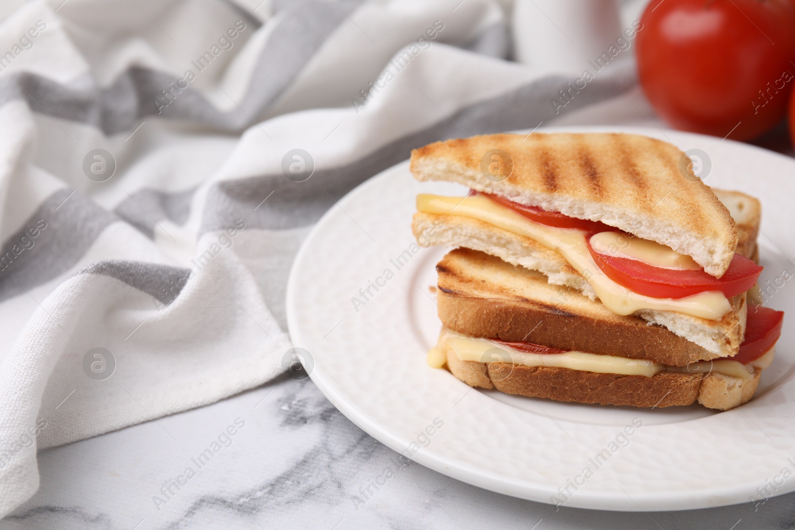 Photo of Pieces of toasted bread with melted cheese and tomato on light marble table, closeup. Space for text