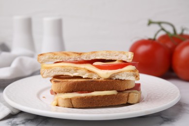 Photo of Pieces of toasted bread with melted cheese and tomato on table, closeup