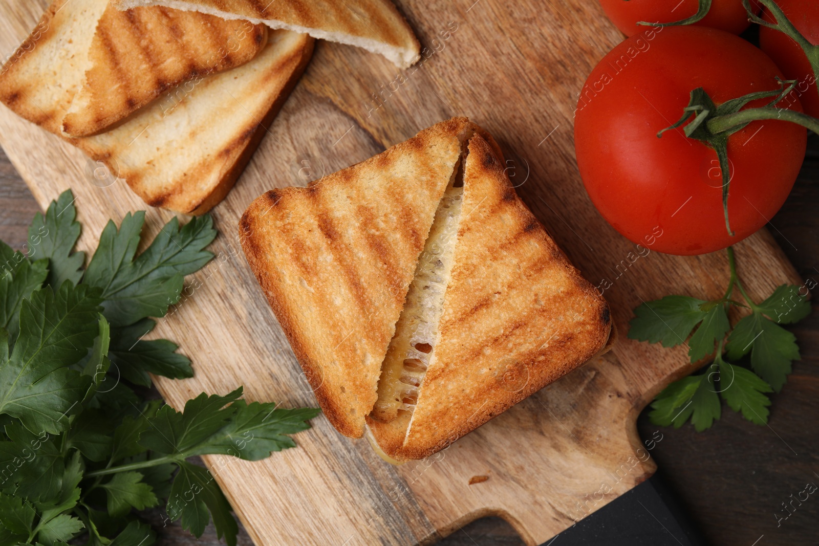 Photo of Pieces of toasted bread with melted cheese, tomatoes and parsley on table, top view