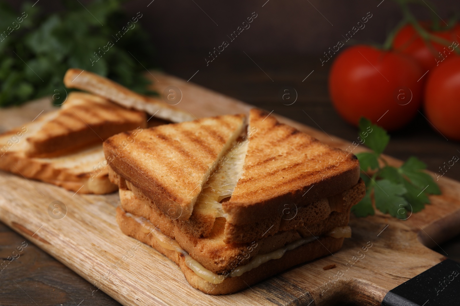 Photo of Pieces of toasted bread with melted cheese on wooden table, closeup