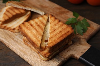 Pieces of toasted bread with melted cheese on wooden table, closeup