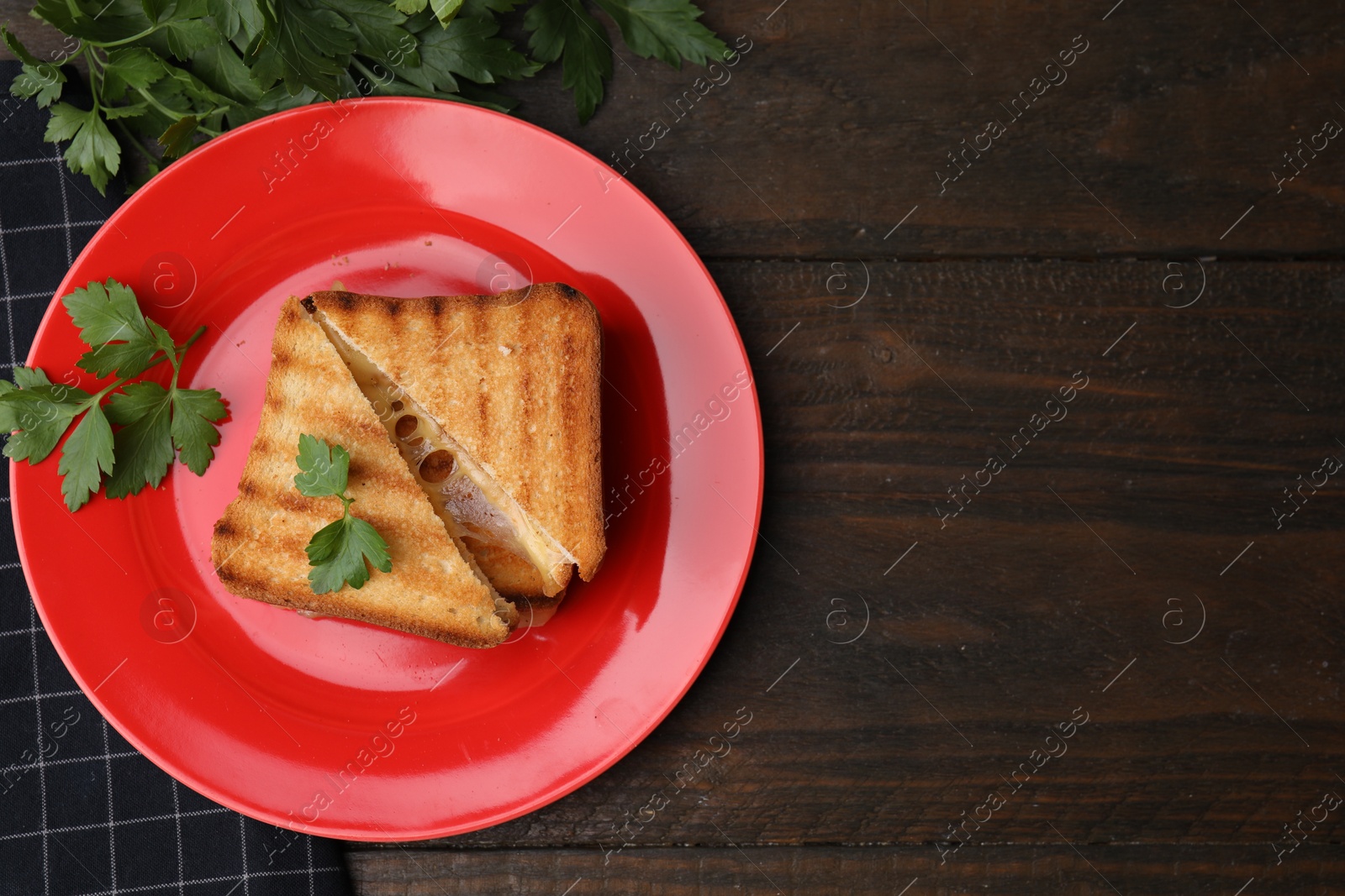 Photo of Pieces of toasted bread with melted cheese and parsley on wooden table, flat lay. Space for text